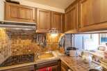Discover the charm of this kitchen, featuring warm wooden cabinetry and a stylish tiled backsplash.