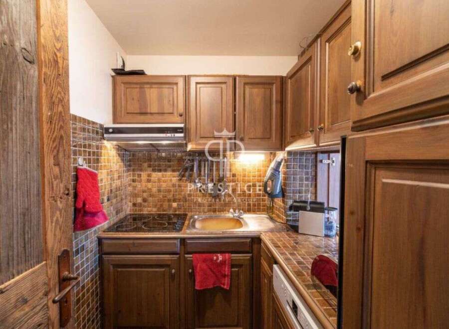 Discover the charm of this cozy kitchen, featuring warm wooden cabinetry and a stylish tiled backsplash.