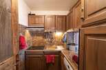 Discover the charm of this cozy kitchen, featuring warm wooden cabinetry and a stylish tiled backsplash.