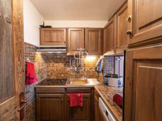 Discover the charm of this cozy kitchen, featuring warm wooden cabinetry and a stylish tiled backsplash.