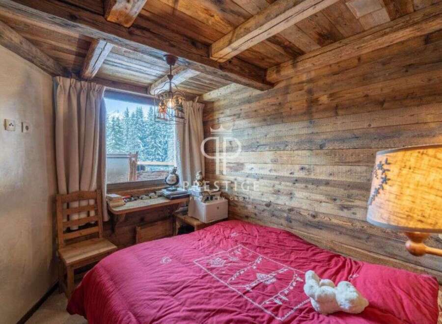 Cozy chalet bedroom with rustic wooden walls and ceiling.
