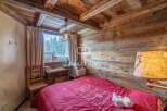 Cozy chalet bedroom with rustic wooden walls and ceiling.