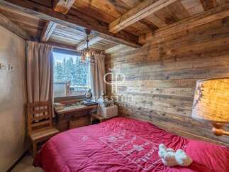 Cozy chalet bedroom with rustic wooden walls and ceiling.
