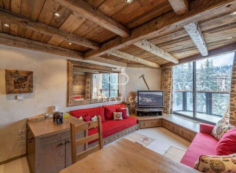 Experience the charm of this cozy chalet, featuring a rustic wooden ceiling and a warm, inviting atmosphere.
