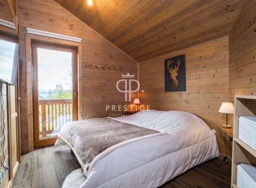 Experience rustic charm in this cozy bedroom, featuring stunning wooden paneling and a vaulted ceiling.