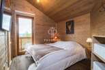 Experience rustic charm in this cozy bedroom, featuring stunning wooden paneling and a vaulted ceiling.