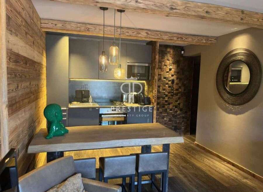 Experience luxury living in this stunning property, featuring a modern kitchen with sleek cabinetry and pendant lighting.