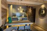 Experience luxury living in this stunning property, featuring a modern kitchen with sleek cabinetry and pendant lighting.