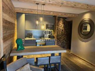 Experience luxury living in this stunning property, featuring a modern kitchen with sleek cabinetry and pendant lighting.