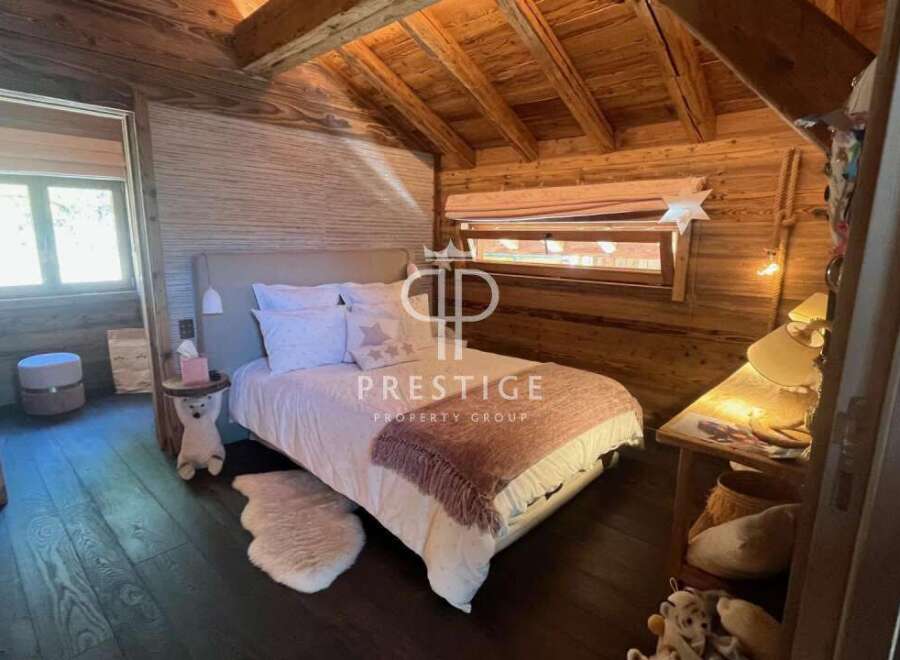 Experience rustic charm in this cozy bedroom, featuring warm wooden accents and a unique sloped ceiling.