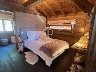Experience rustic charm in this cozy bedroom, featuring warm wooden accents and a unique sloped ceiling.