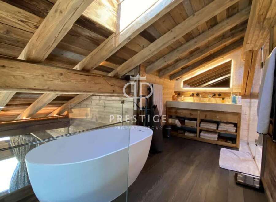 Experience luxury in this stunning property featuring a unique wooden ceiling and a modern bathtub.