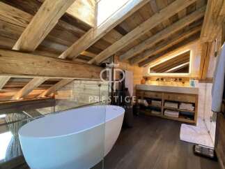 Experience luxury in this stunning property featuring a unique wooden ceiling and a modern bathtub.
