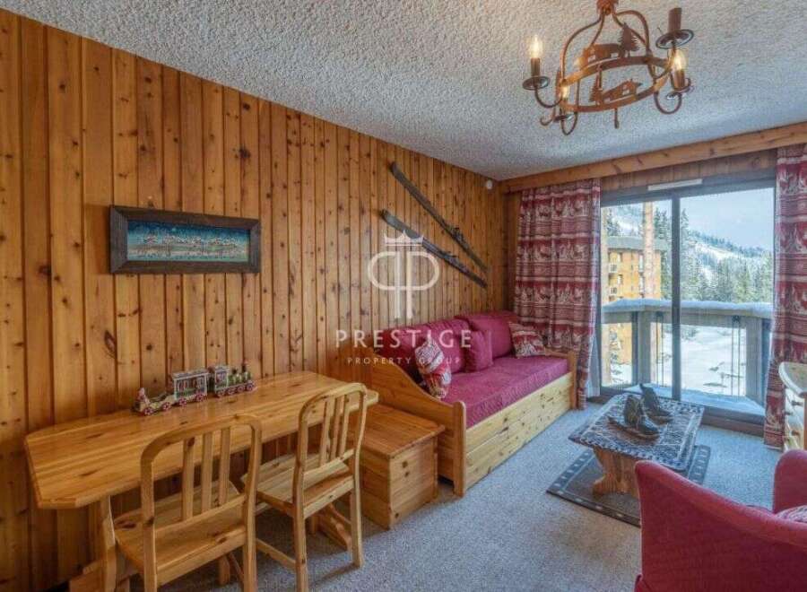 Cozy mountain retreat with rustic wooden paneling and a charming chandelier.