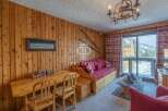 Cozy mountain retreat with rustic wooden paneling and a charming chandelier.