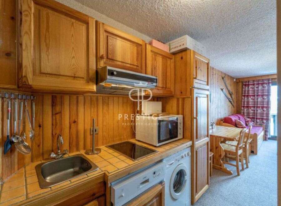 Cozy kitchen with wooden cabinets and a microwave.