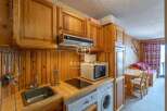 Cozy kitchen with wooden cabinets and a microwave.