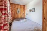 Cozy bedroom with wooden paneling and charming decor.