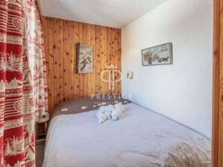 Cozy bedroom with wooden paneling and charming decor.