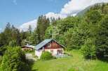 Discover a charming chalet nestled in a serene, green landscape.