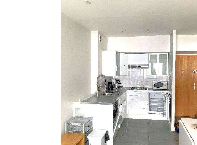 Modern kitchen with sleek countertops and white cabinetry.