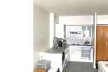 Modern kitchen with sleek countertops and white cabinetry.
