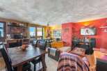 Discover a cozy living space with a rustic dining table and comfortable seating.