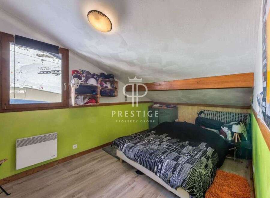 Discover this charming bedroom with a unique slanted ceiling and a cozy atmosphere.