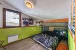 Discover this charming bedroom with a unique slanted ceiling and a cozy atmosphere.