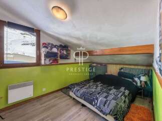 Discover this charming bedroom with a unique slanted ceiling and a cozy atmosphere.