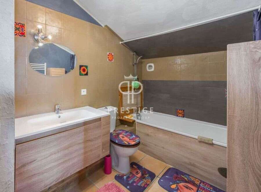 Discover this charming bathroom featuring a stylish vanity and a modern sink.