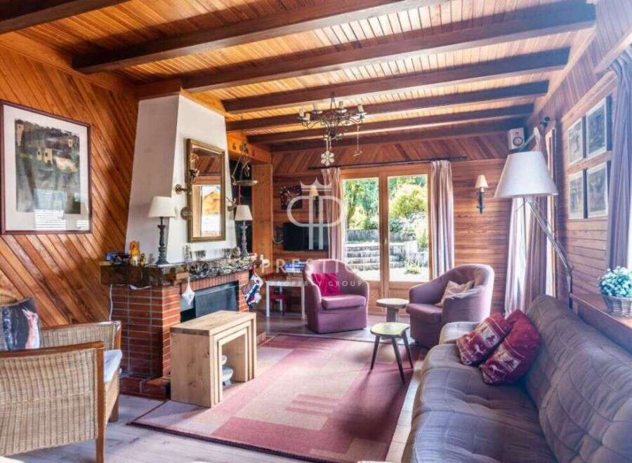 Step into a cozy retreat with this charming property, featuring a warm wooden interior and a welcoming fireplace.