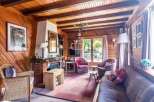Step into a cozy retreat with this charming property, featuring a warm wooden interior and a welcoming fireplace.