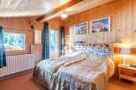 Cozy bedroom with wooden paneling and a comfortable bed.