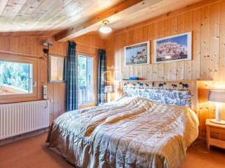 Cozy bedroom with wooden paneling and a comfortable bed.