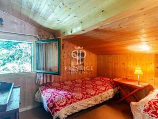 Cozy cabin bedroom with wooden walls and ceiling.
