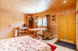 Cozy chalet bedroom with wooden walls and ceiling, creating a warm and inviting atmosphere.
