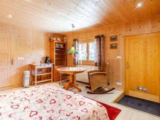 Cozy chalet bedroom with wooden walls and ceiling, creating a warm and inviting atmosphere.