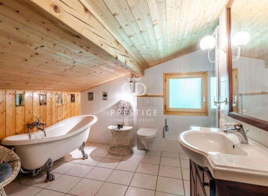Discover a charming bathroom with a unique wooden ceiling and walls, creating a warm and inviting atmosphere.