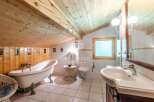 Discover a charming bathroom with a unique wooden ceiling and walls, creating a warm and inviting atmosphere.