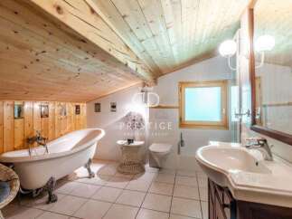 Discover a charming bathroom with a unique wooden ceiling and walls, creating a warm and inviting atmosphere.