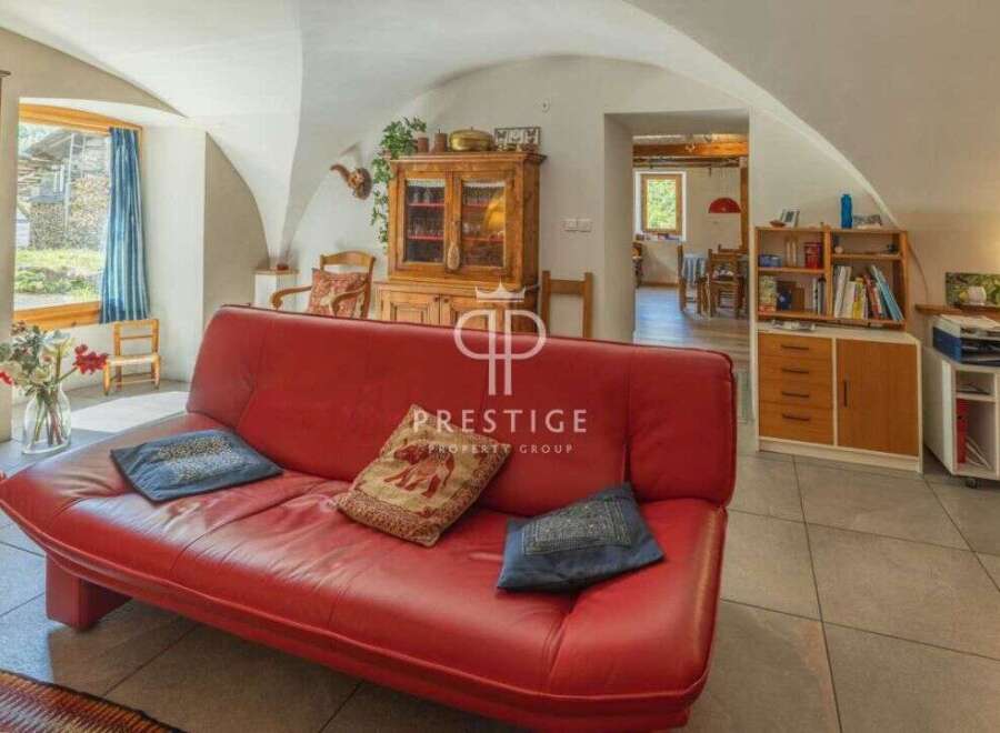 Discover the charm of this stunning property, featuring a spacious living area with a vibrant red sofa.