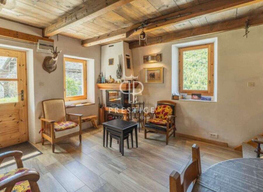 Discover the charm of this rustic property, featuring a cozy living room with a fireplace and wooden beams.