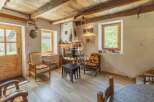 Discover the charm of this rustic property, featuring a cozy living room with a fireplace and wooden beams.