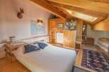Discover a cozy bedroom with a rustic charm, featuring exposed wooden beams and a comfortable bed.