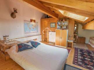 Discover a cozy bedroom with a rustic charm, featuring exposed wooden beams and a comfortable bed.