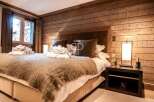 Experience luxury in this stunning bedroom featuring a cozy, oversized bed with a plush, textured throw.