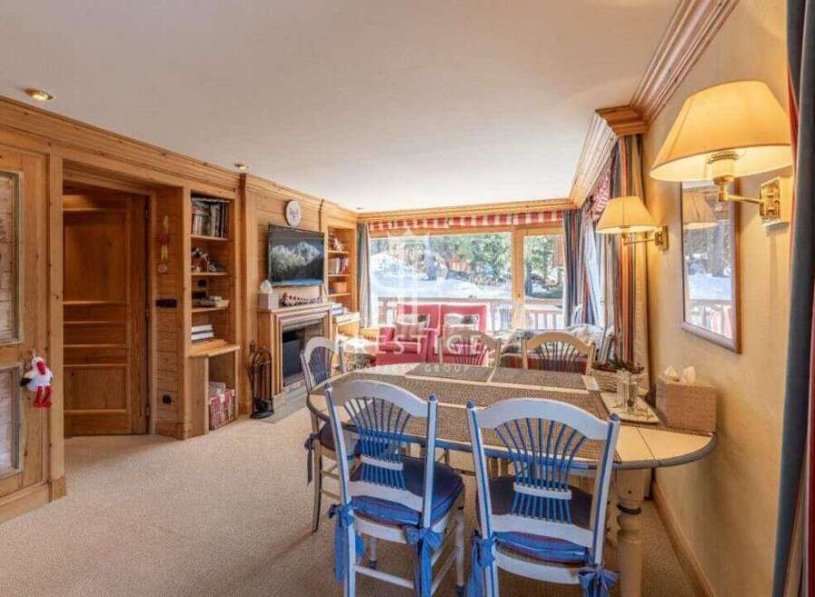 Experience the charm of this cozy chalet, featuring a warm wooden interior and a welcoming dining area.