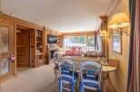 Experience the charm of this cozy chalet, featuring a warm wooden interior and a welcoming dining area.