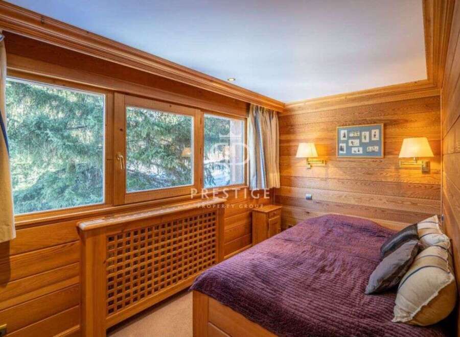 Experience the warmth of this cozy bedroom, featuring stunning wooden paneling and a serene ambiance.